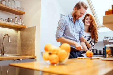Çift mutfakta taze organik meyve suyu yapıyor.
