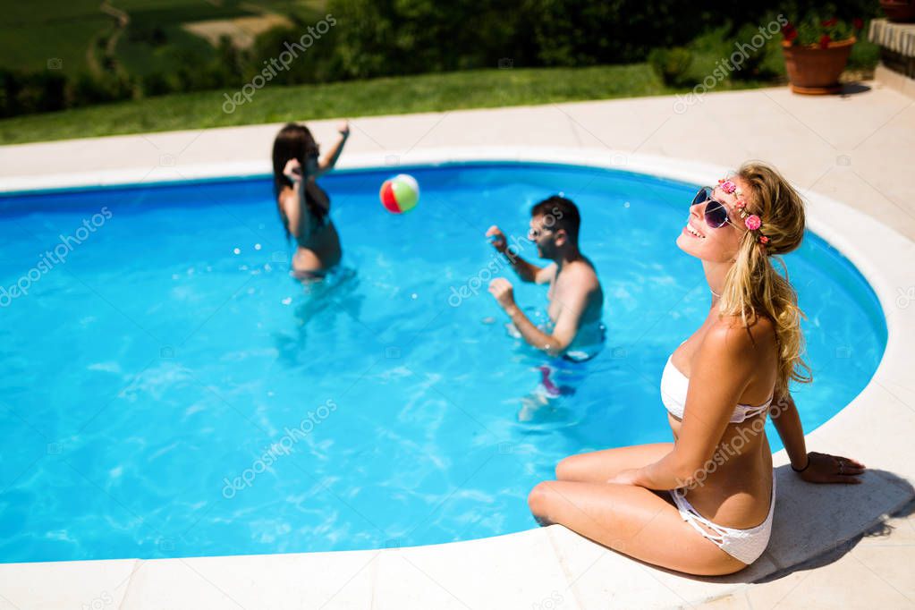 Friends playing ball games in swimming pool