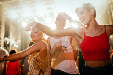 Mutlu genç arkadaşlar müzik festivalinde eğleniyor.