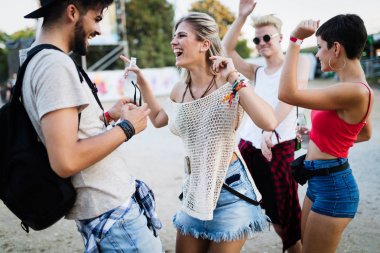Mutlu genç arkadaşlar müzik festivalinde eğleniyor.