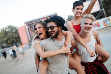 Mutlu genç arkadaşlar müzik festivalinde eğleniyor.