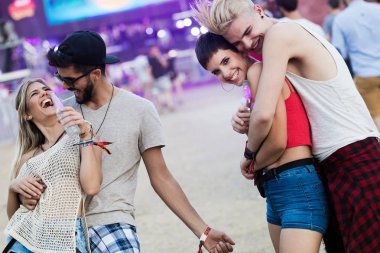 Mutlu genç arkadaşlar müzik festivalinde eğleniyor.