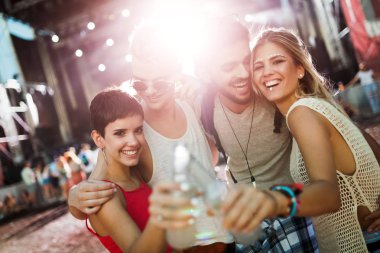 Mutlu genç arkadaşlar müzik festivalinde eğleniyor.