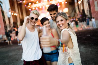 Mutlu genç arkadaşlar müzik festivalinde eğleniyor.