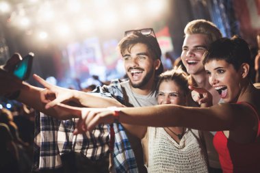 Mutlu genç arkadaşlar müzik festivalinde eğleniyor.