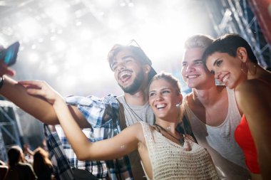 Mutlu genç arkadaşlar müzik festivalinde eğleniyor.