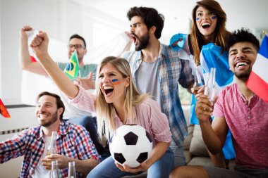 Futbol fanatikleri duygusal olarak oturma odasında maç izleyip çığlık atıyorlar.