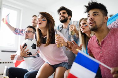 Futbol fanatikleri duygusal olarak oturma odasında maç izleyip çığlık atıyorlar.