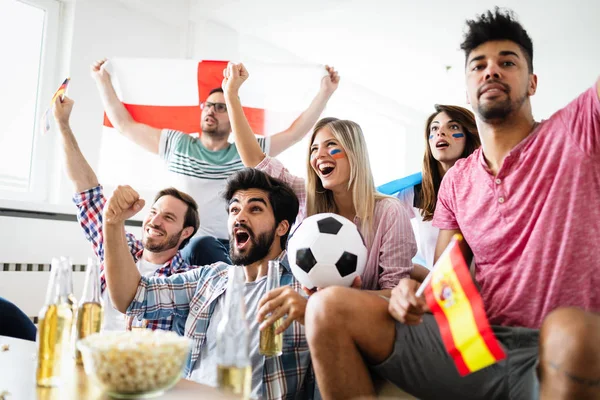 Soccer fans emotionally watching game and screaming in the living room