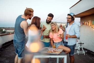 Bir grup genç insan çevresinde oturan ve pizza yemek. Parti ve pizza yemek arkadaşlar.