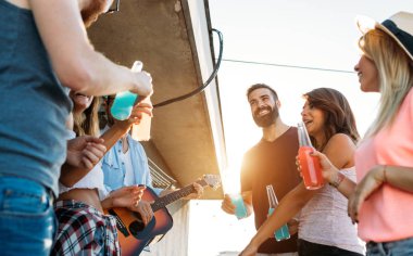 Arkadaşlar eğlenmeye ve kokteyller açık bir çatıda içme bir araya