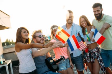 Bir grup ülke bayrakları tutarak ve çatı katında eğleniyor insan