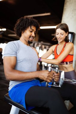 Spor salonunda fit insanlarla egzersiz yapan beden eğitimi hocası..