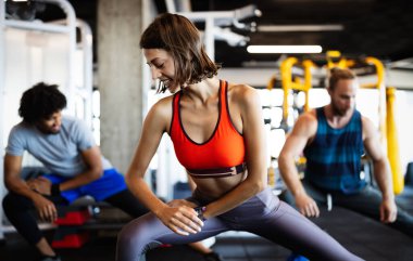 Spor salonunda egzersiz yapan sağlıklı genç sporcular..