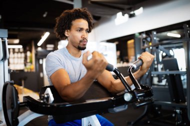 Spor, spor, egzersiz, eğitim ve yaşam tarzı danışmanı. Spor salonunda çalışan sağlıklı bir genç.