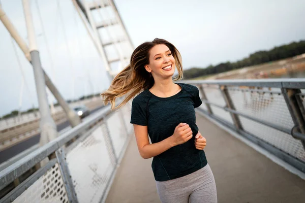 Retrato de la mujer joven en forma y deportivo corriendo al aire libre — Foto de Stock