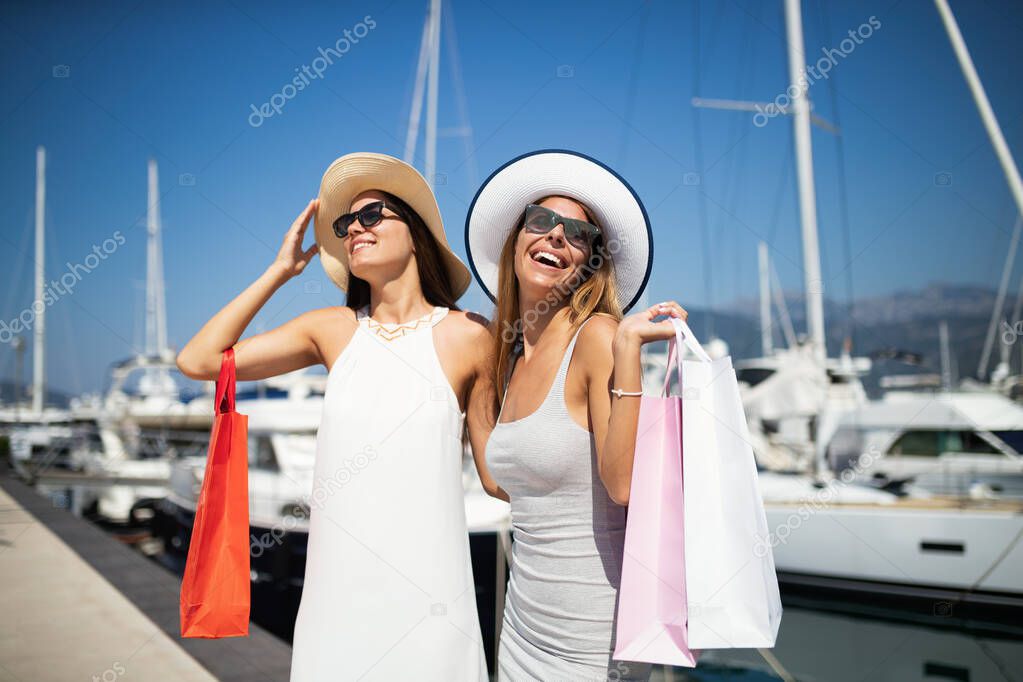 Shopping and tourism, vacation, happy, friends, people concept. Beautiful women with shopping bags at summer