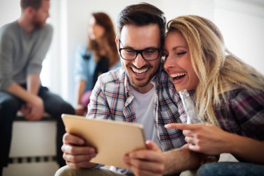 Evde dijital tablet kullanan neşeli çift ve rahatlatıcı