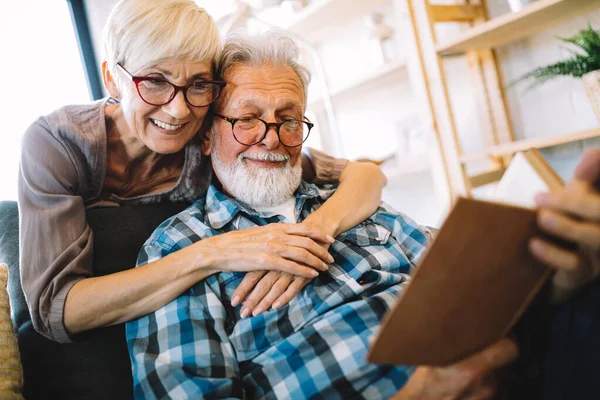 Casal Velho Bonito Está Lendo Livro Sorrindo Enquanto Sentado Casa — Fotografia de Stock