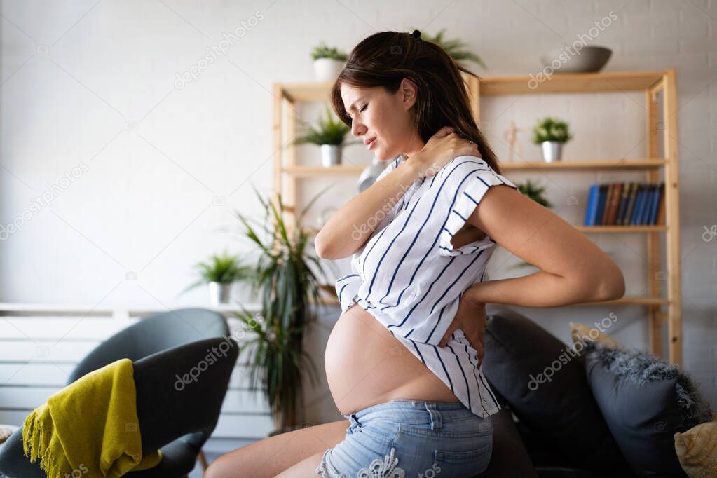Pregnant woman expecting baby with aches, headache and backpain