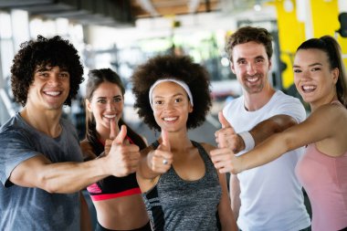 Bir spor salonunda antrenman yapan bir grup insan. Antrenör ve sportif fit insanlar bir fitness sınıfında egzersiz yapıyor