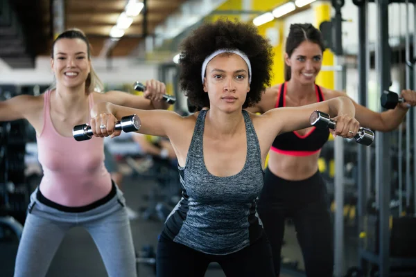 Picture of cheerful young fitness team in gym