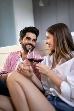 Güzel bir çift yatak odasında birlikte vakit geçirirken gülümsüyor, konuşuyor ve sarılıyor.