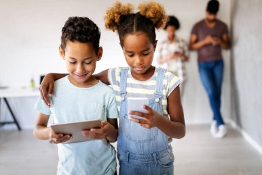 Dijital cihazlar, tabletler, akıllı telefonlar kullanan mutlu bir aile. Teknoloji konsepti