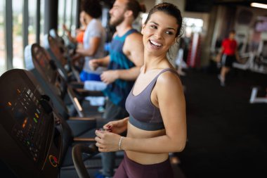 Sağlık kulübünde koşu bandında koşan sağlıklı genç insanlar..