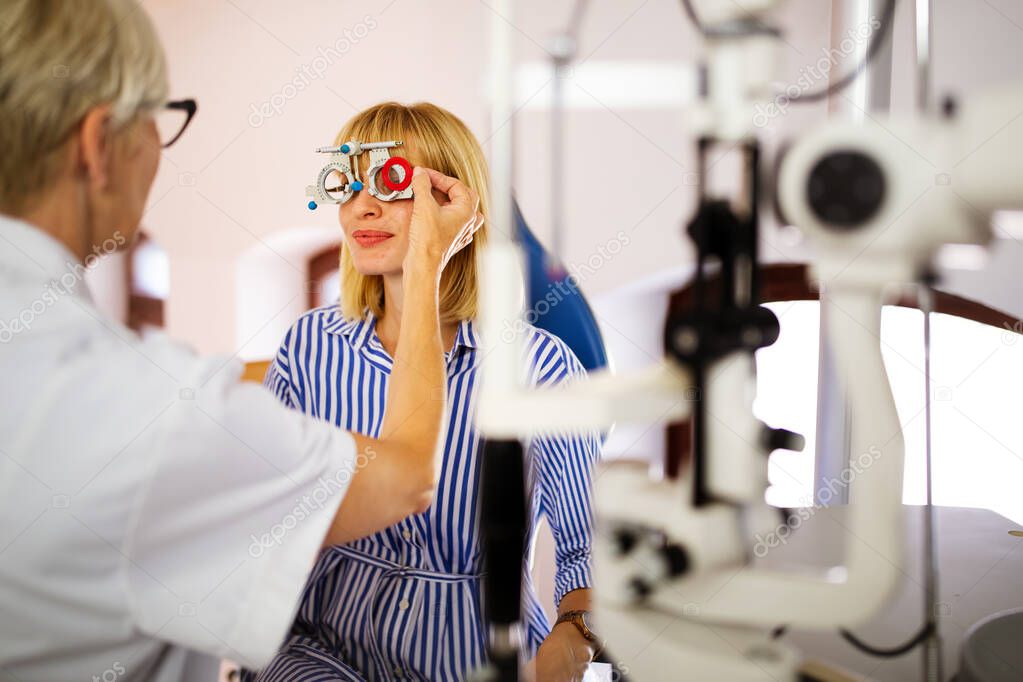 Senior optometrist examining patient in modern ophthalmology clinic
