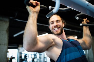 Spor salonunda egzersiz yapan yakışıklı bir genç.