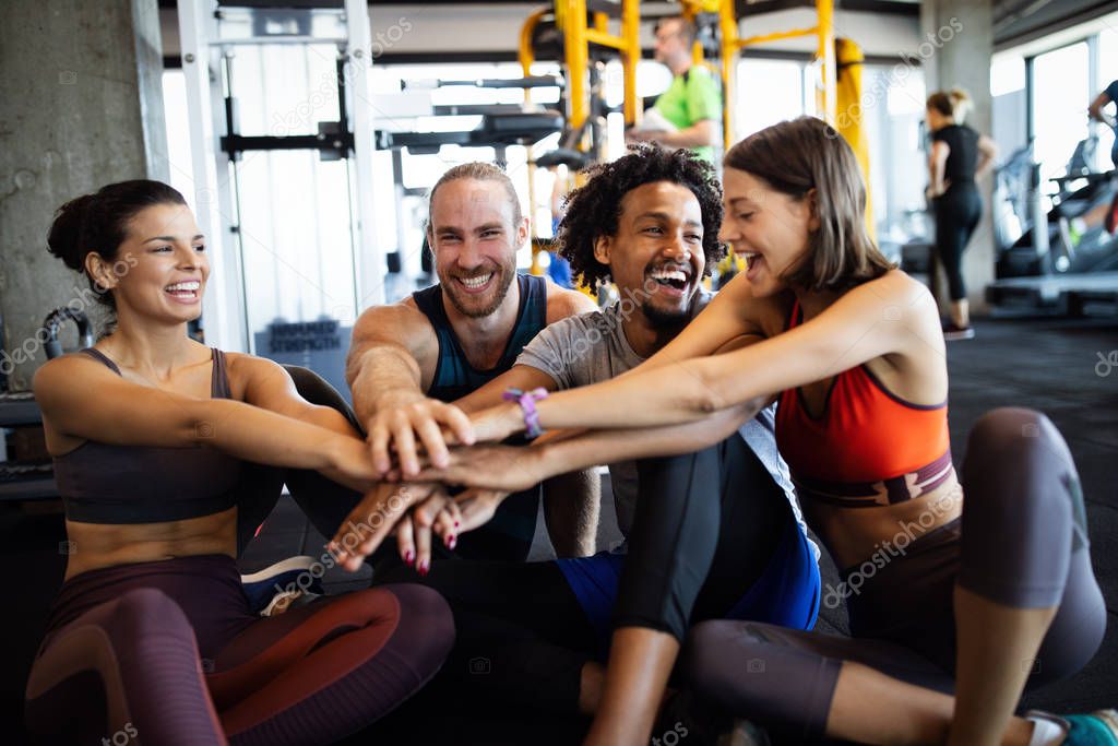Happy fit people exercising, working out in gym to stay healthy together