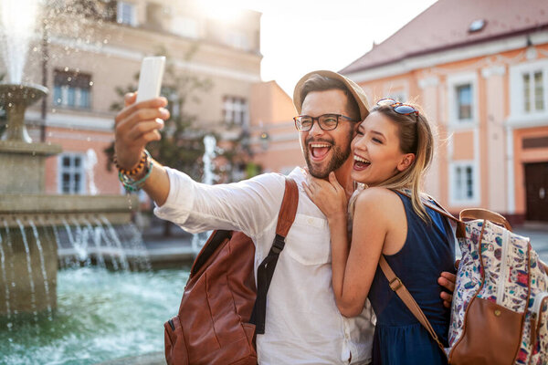 Happy tourist couple in love dating, laughing on vacation