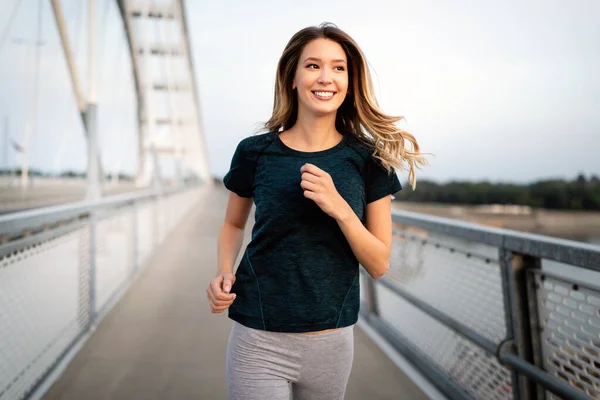 Stock image Portrait of young fit and sporty young woman running in tha city