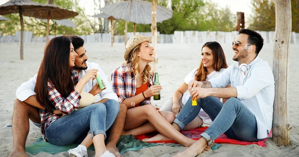 群的年轻朋友笑 在海滩上喝啤酒 — 图库照片