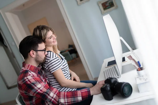 Young attractive couple of designers working on computer