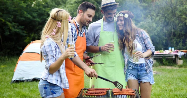 Group of friends having barbecue party in forest