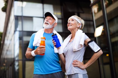 Yaşlı çift enerjilerini tazelemek ve su içmek için su içer.