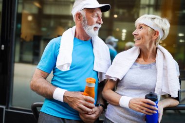 Şehirde koşan olgun bir çift dışarıda koşuyor. Koşucular dışarıda antrenman yapıyor.