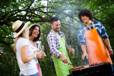Arkadaşlar doğada barbekü yaparken eğleniyorlar.