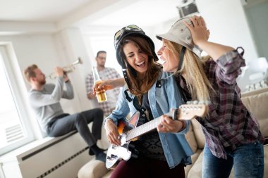 Arkadaşlar evde şarkı söyleme ve gitar çalmanın, eğlenin