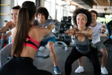 Spor salonunda egzersiz yapan bir grup formda genç.