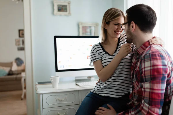 Young attractive couple of designers working on computer