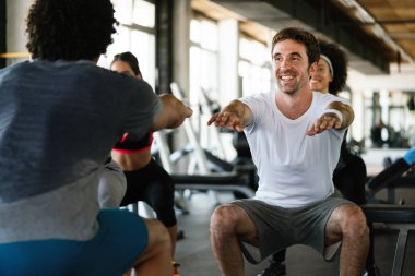 Spor salonunda egzersiz yapan bir grup formda genç.