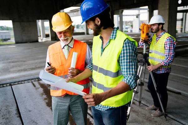 Två Nöjda Ingenjörer Arkitekter Talar Byggarbetsplats Med Byggstruktur Bakgrunden — Stockfoto