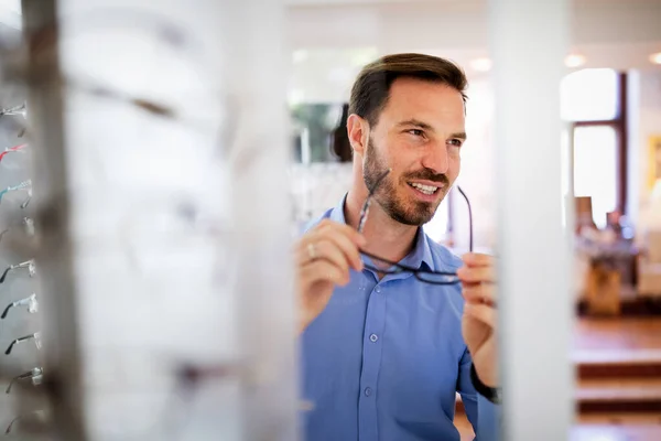 Handsome Young Man Choosing Glasses Optics Store — Stock Photo, Image