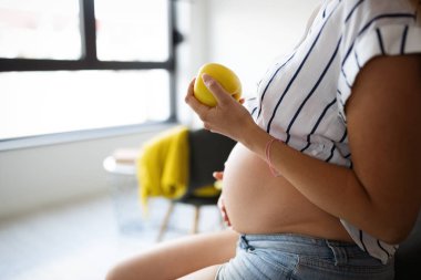 Güzel, genç, hamile bir kadın sağlıklı yemek yiyor.