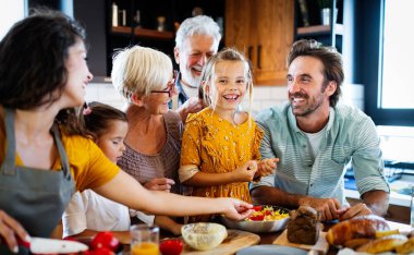 Büyükbabalar, ebeveynler ve çocuklar mutfakta mutlu vakit geçiriyorlar. Aile yemekleri konsepti