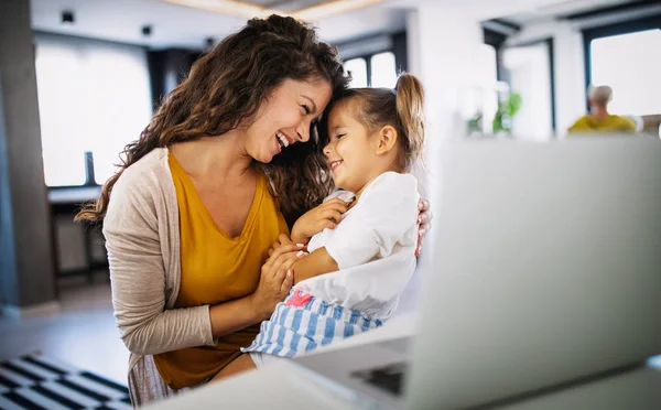 Beautiful mother at home trying to work with child distracting her