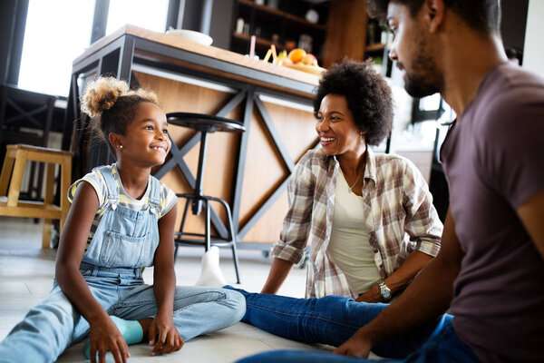 Happy african american family talking and smiling together at home